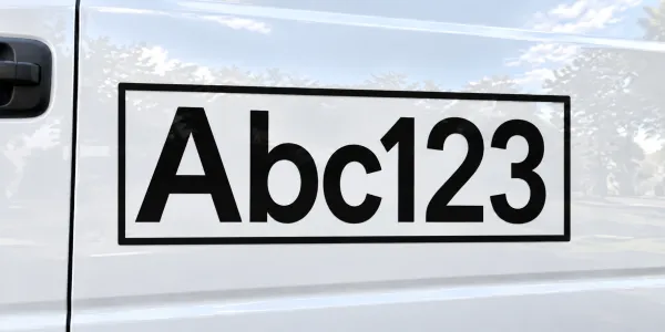 Schwarze Buchstaben mit schwarzem Rahmen auf einem weißen Auto